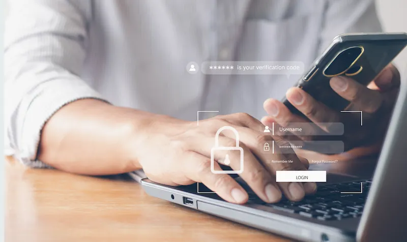 Person on laptop looking at phone