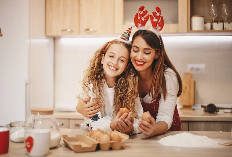 Mother and child holding eggs while baking